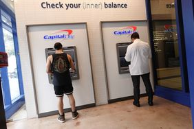 Customers make a transaction at a Capital One ATM on February 19, 2024, in Miami, Florida. 