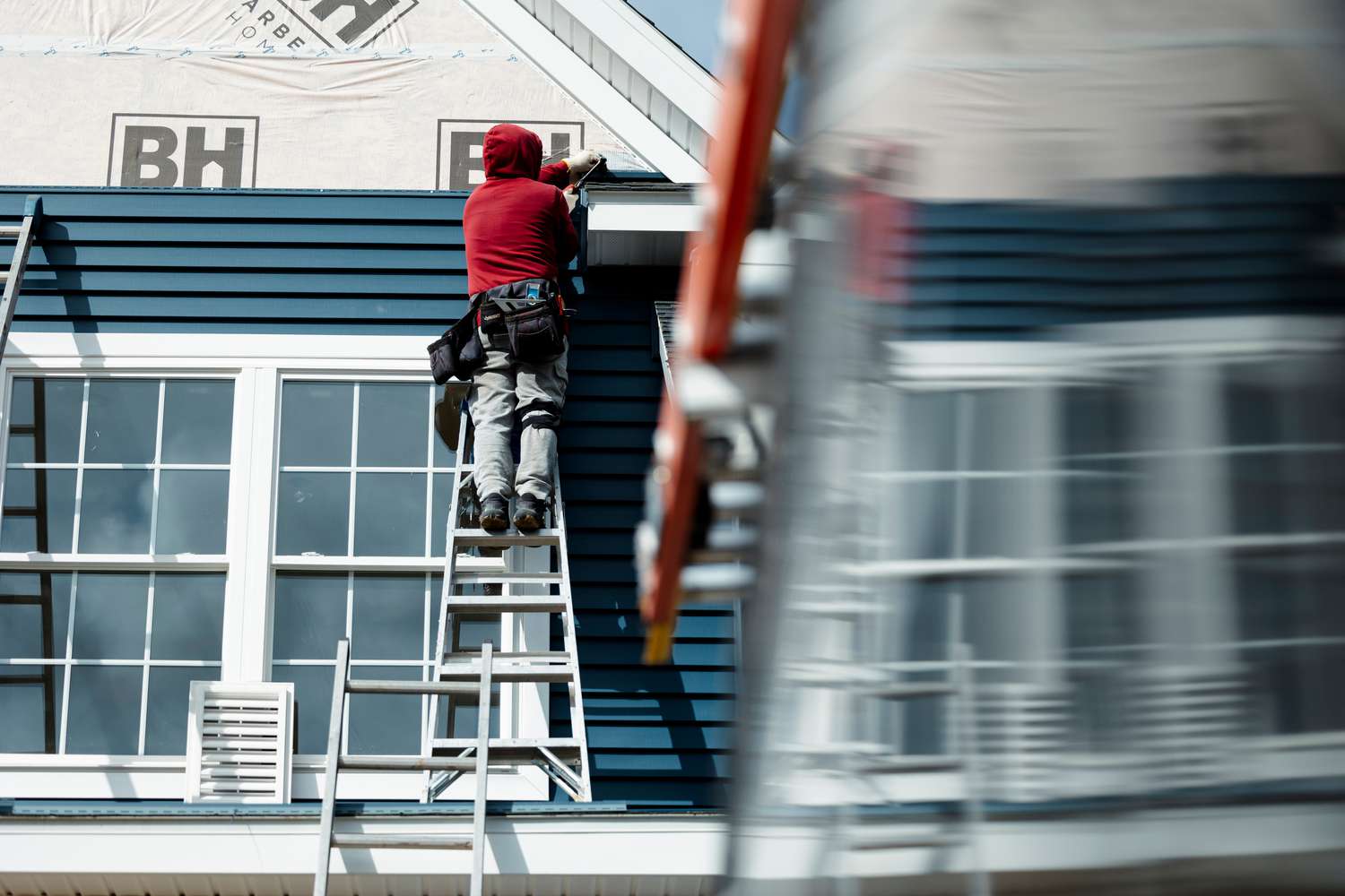 A worker installs siding on a home under construction at the Cold Spring Barbera Homes subdivision in Loudonville, New York, US, on Tuesday Oct. 15, 2024. 