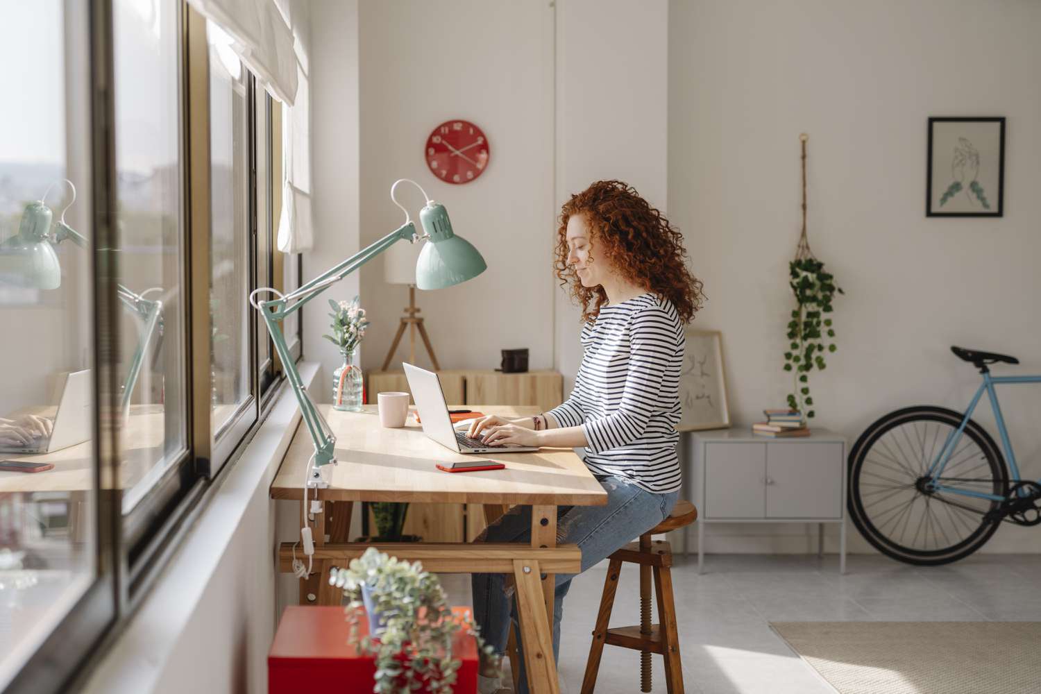 Woman sitting on a desk using a laptop computer while working from home. 
