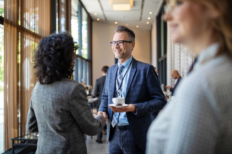 Male and female business owners greeting each other at a seminar