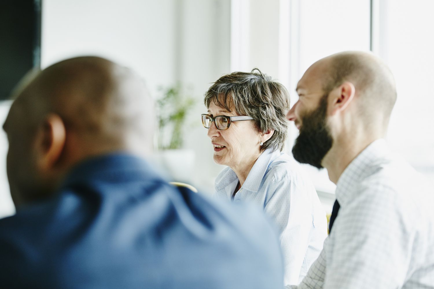 A business meeting convenes in an office setting.