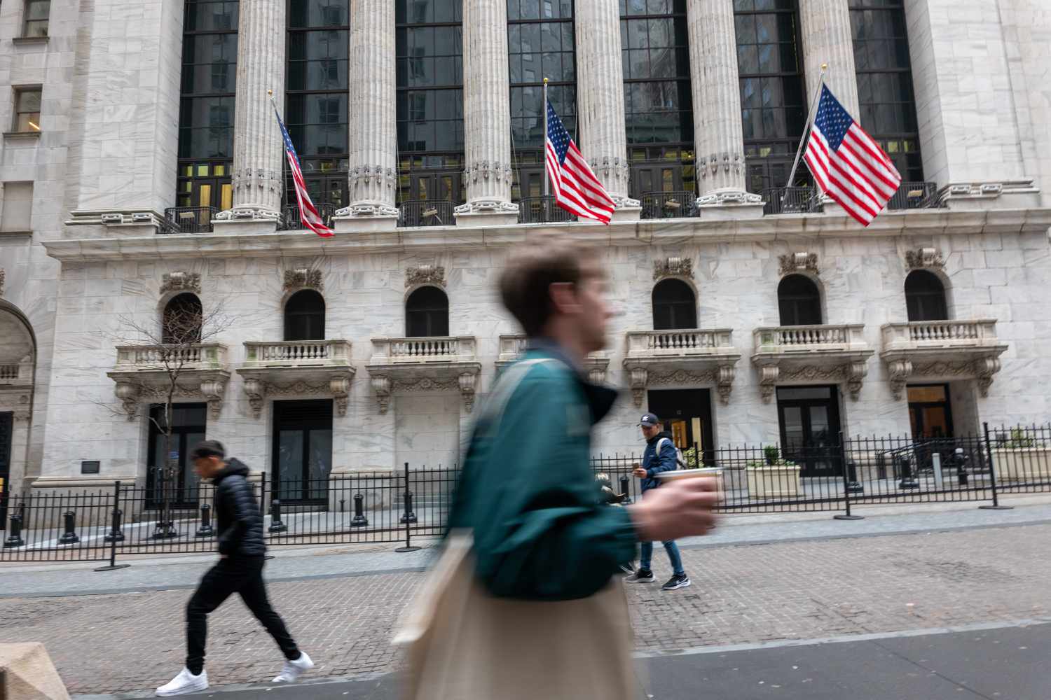 People walk by the New York Stock Exchange (NYSE).
