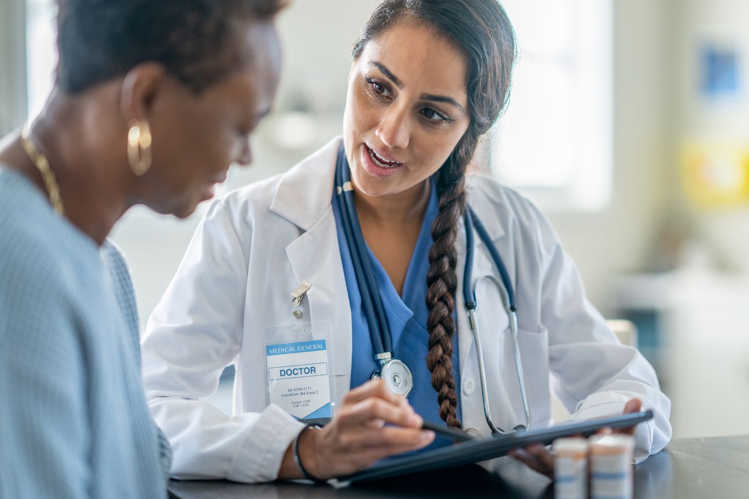 A doctor reviews medications with an older woman