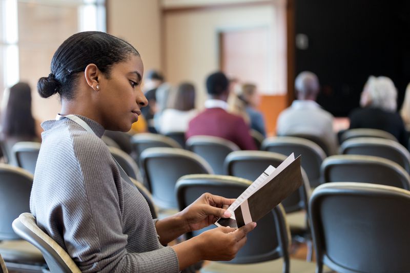 Woman reads a college pamphlet about how to get the maximum student financial aid