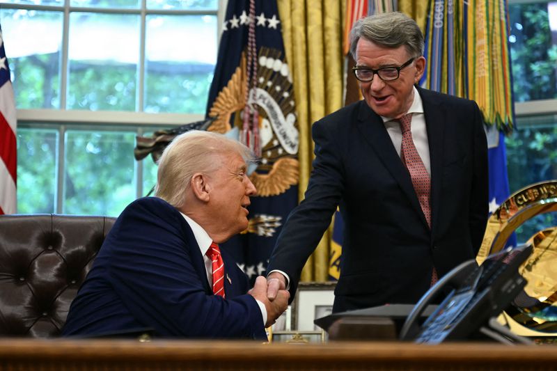 Donald Trump shakes hands with Peter Mandelson. Trump is sitting behind a desk in the Oval Office and Mandelson is standing to his left. 