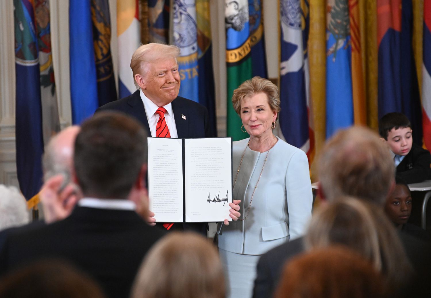 U.S. President Donald Trump holding up a signed executive order poses with U.S. Education Secretary Linda McMahon at the White House on March 20, 2025 in Washington, DC.
