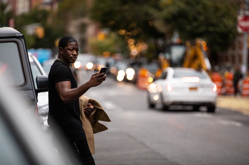 Man with phone in his hand, waiting for a car service.