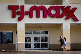 Two consumers walk toward a TJ Maxx store. 