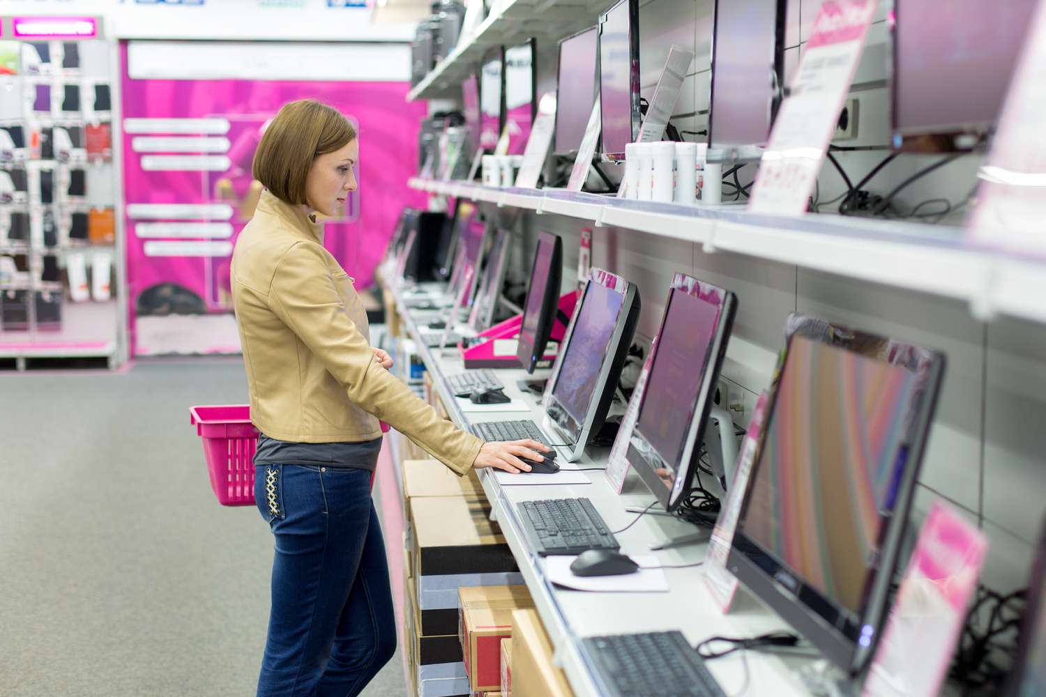A woman looks at computers at a retail store. 