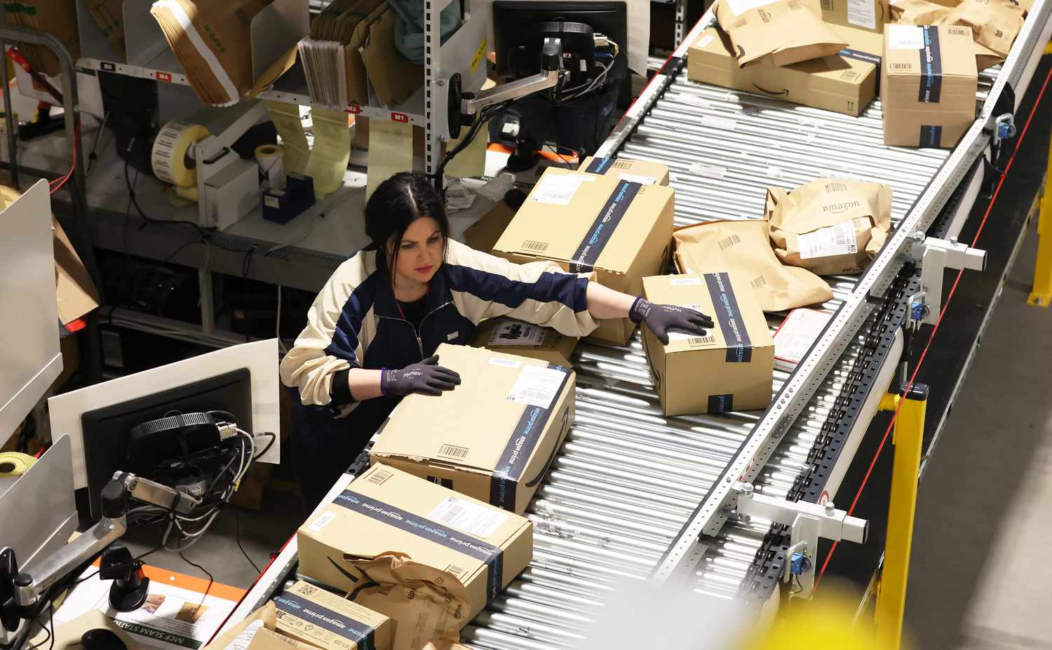 A woman works on an assembly line at an Amazon fulfillment center