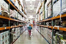 A shopper walks down a Costco aisle. 