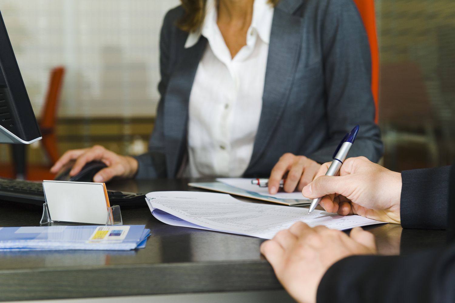Person in a suit signing a document