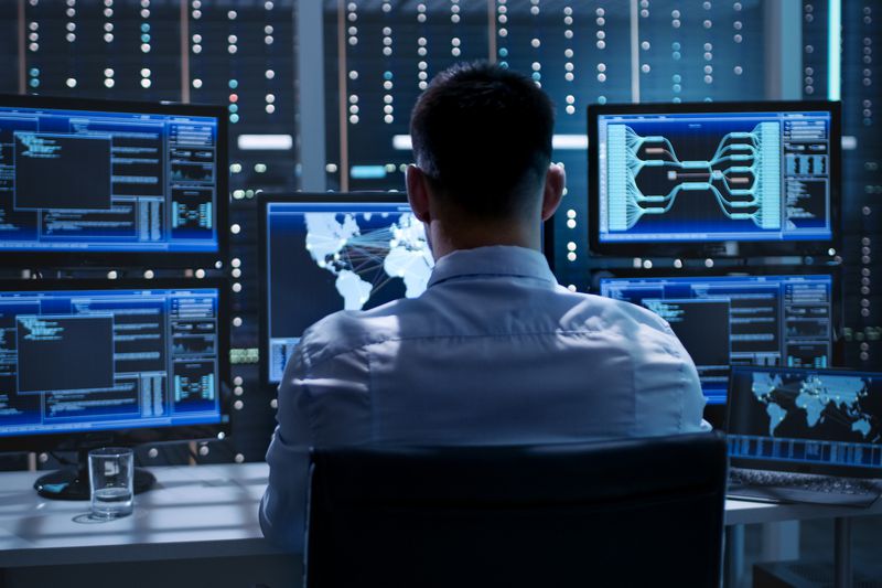 A man at a desk with multiple monitors