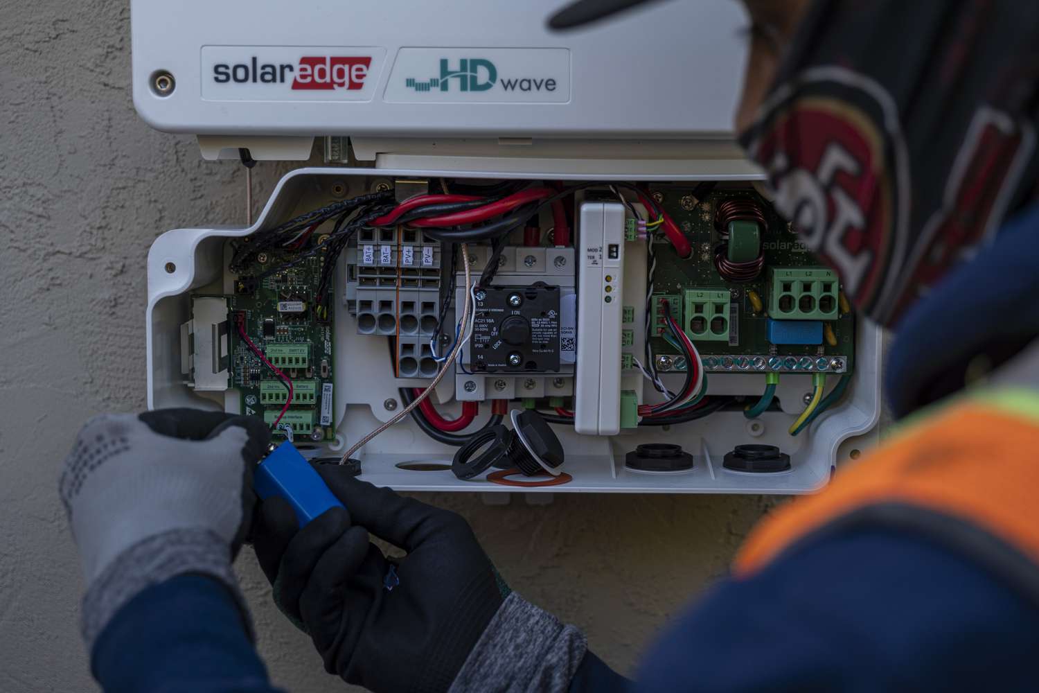A contractor installs a SolarEdge solar inverter at a home in San Jose, California