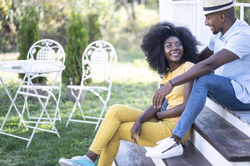 Couple sitting in front of their house.