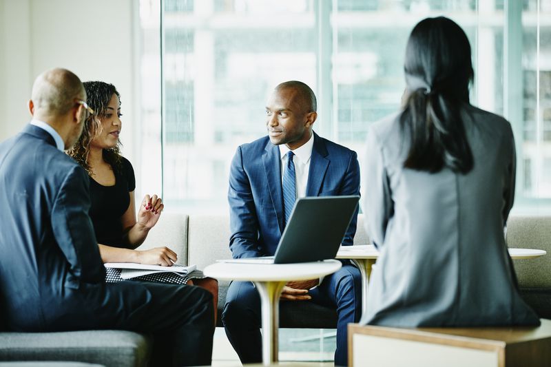 business people in a meeting with a laptop in the center