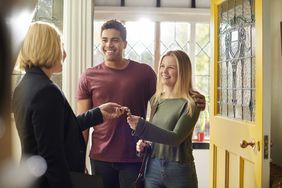 A landlord handing keys to tenants
