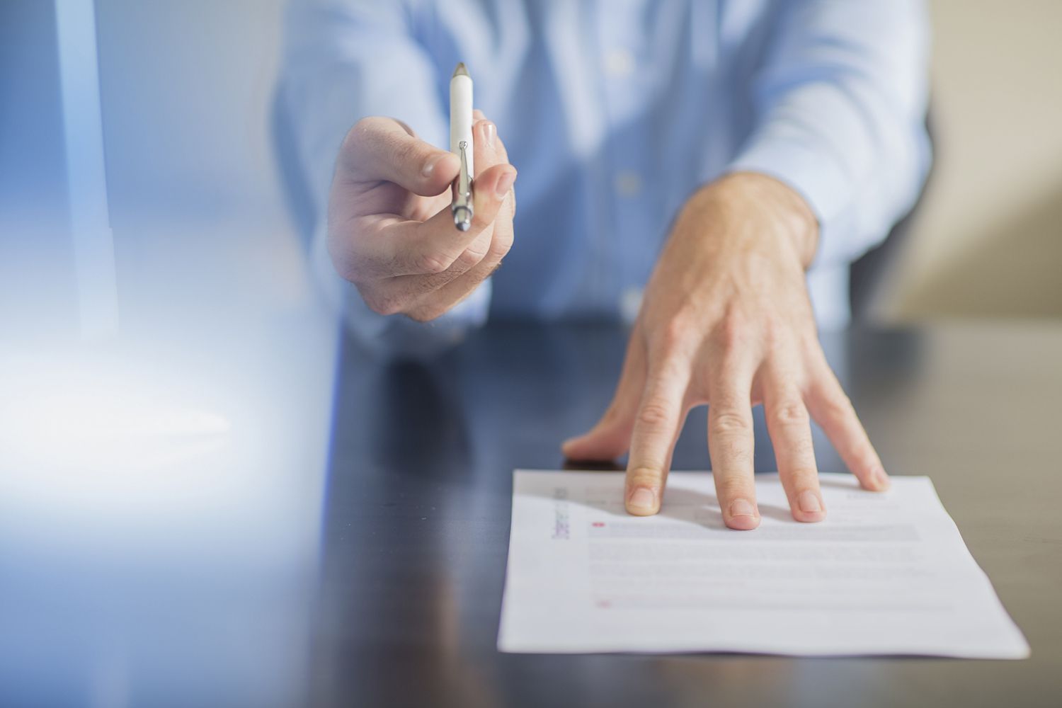 Person presenting a pen to sign a contract
