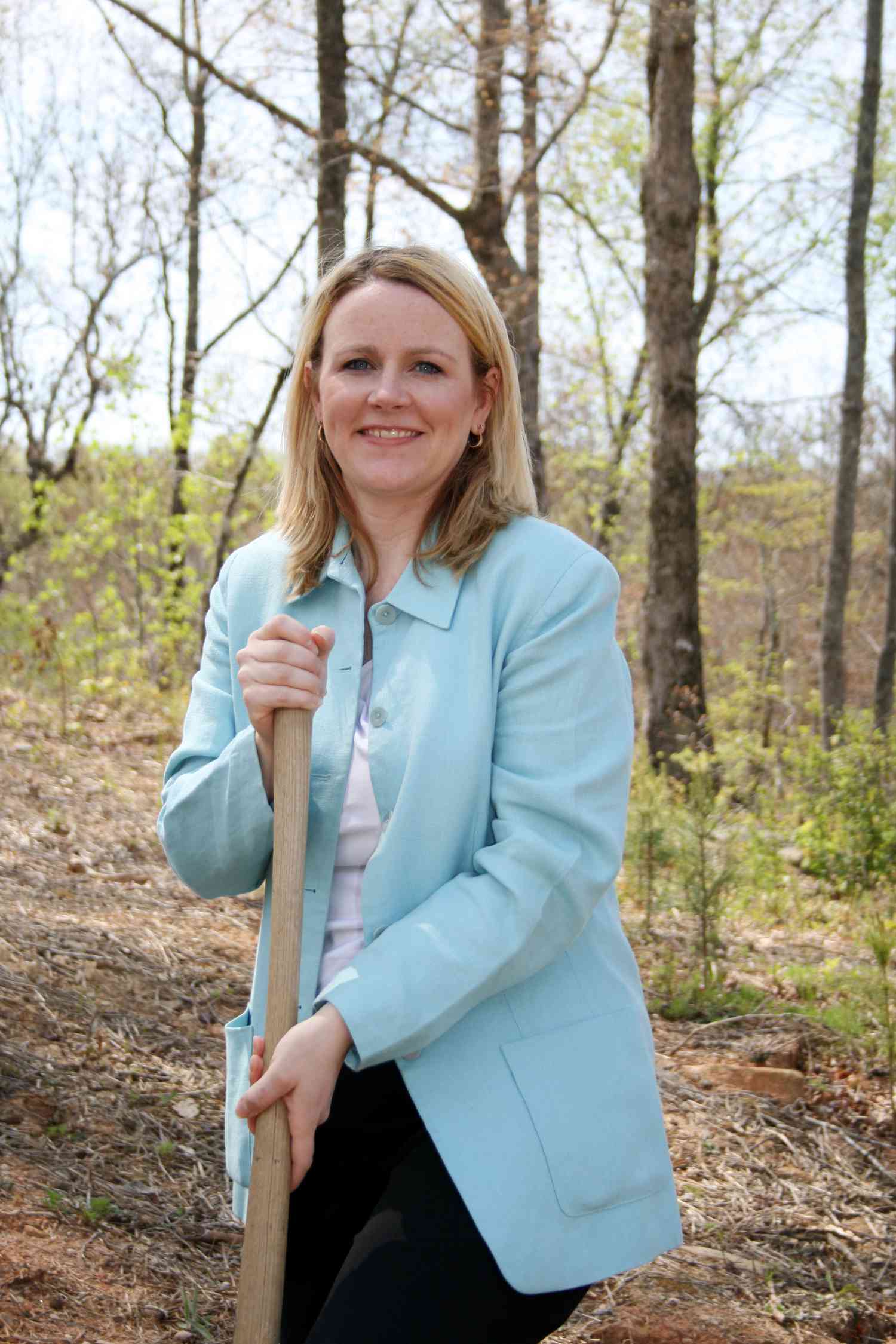 A well-dressed city official holds a shovel as they ceremonially break ground for a new shopping center which will broaden the city tax base.
