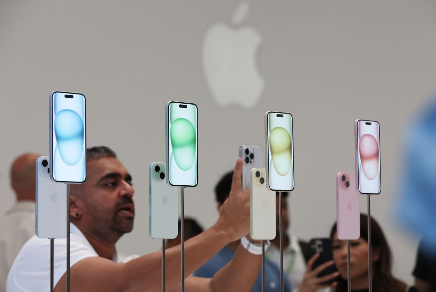 People demo new iPhones at an Apple event. 