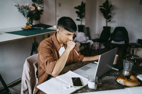 A worker with a laptop in an office