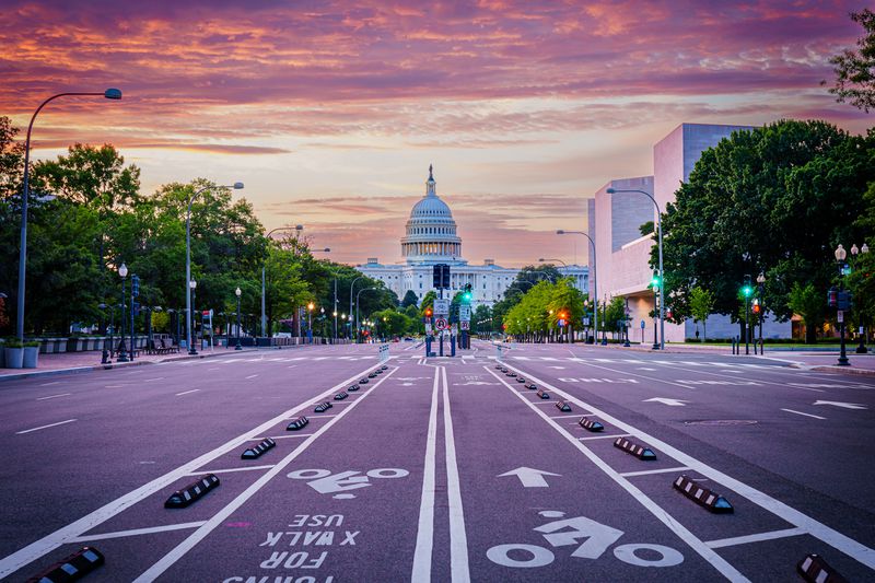 Sunrise on Pennsylvania Avenue with no cars on the road and the capital in the background