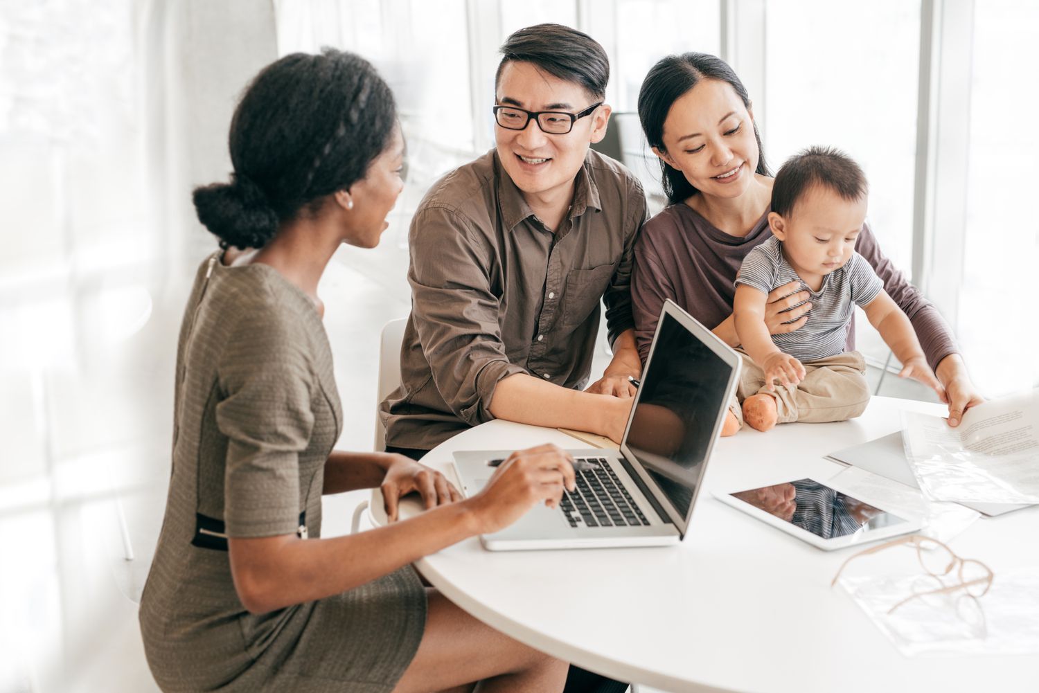A couple with a new baby getting financial advice from an accountant or tax preparer.