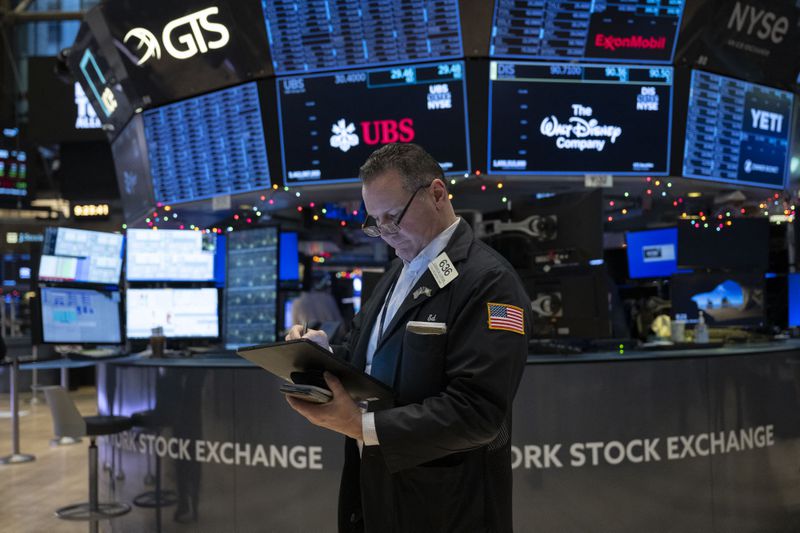 A trader looks down at a tablet on the floor of the New York Stock Exchange