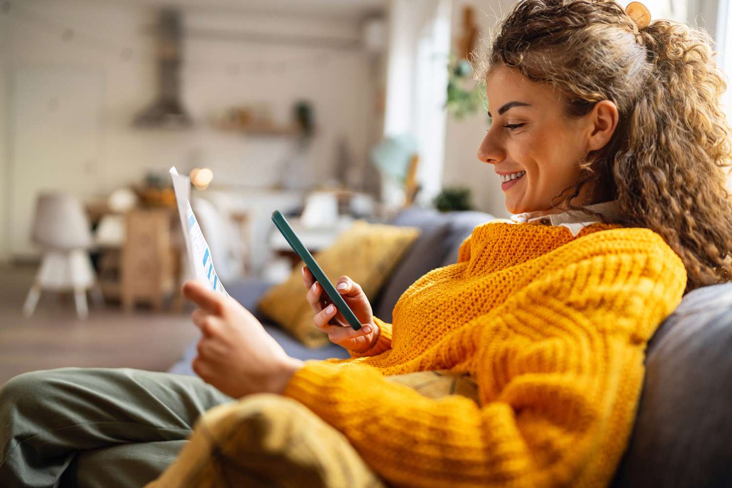 Side-view of someone using a smartphone to check investments.