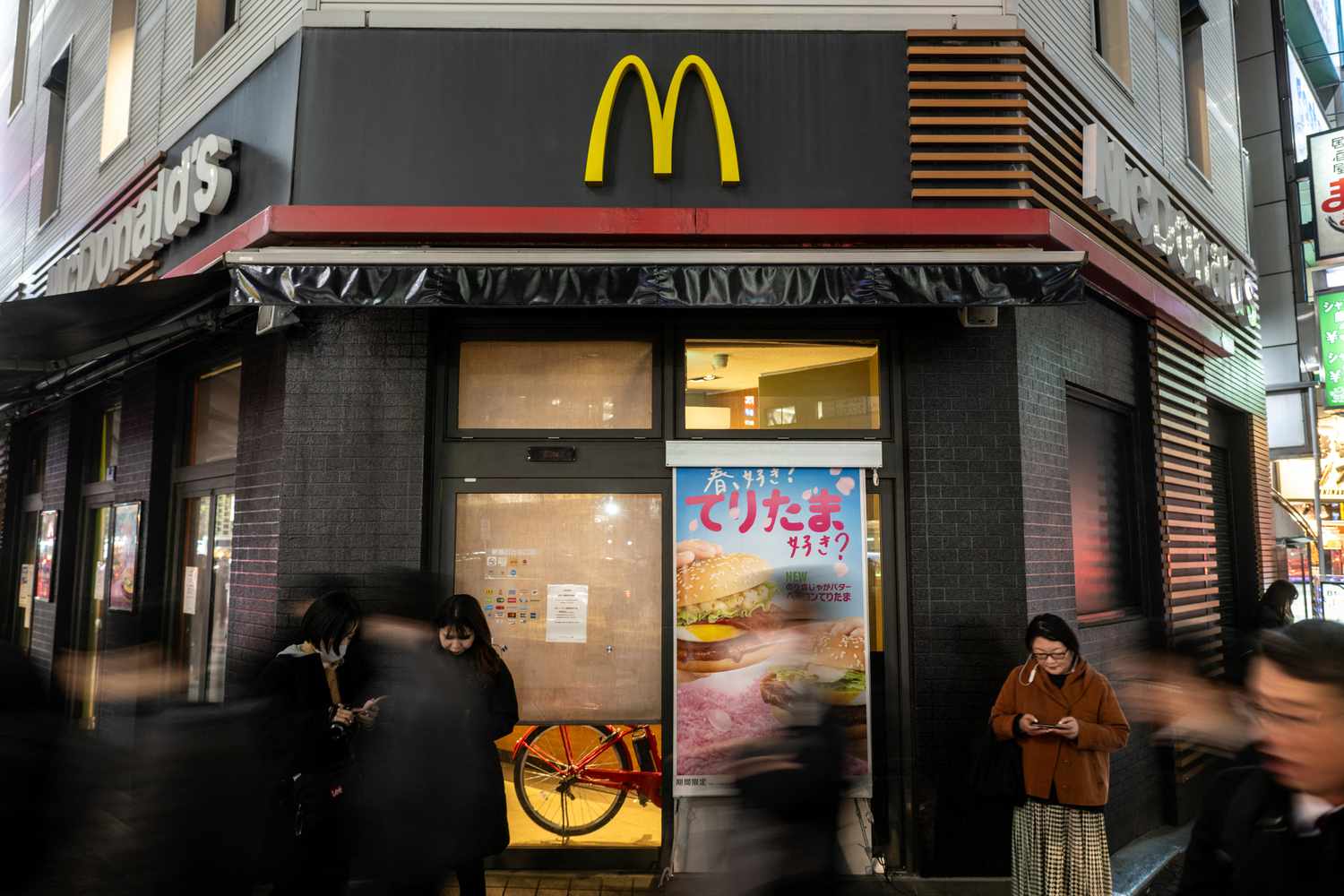People stand in front of a temporary closed McDonald's in Shimbashi district of Tokyo on March 15, 2024.