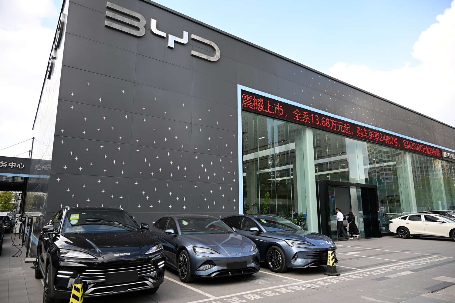 A group of black and silver electric vehicle sit outside a BYD store in China.