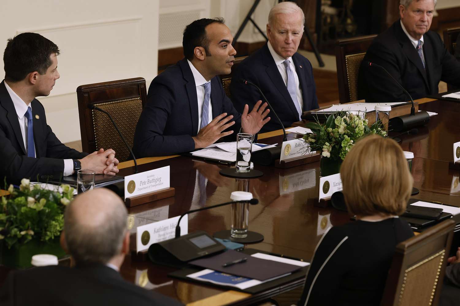 Consumer Financial Protection Bureau Director Rohit Chopra (2nd L) delivers brief remarks during a meeting with U.S. President Joe Biden (3rd L) and other members of the White House Competition Council, Transportation Secretary Pete Buttigieg (L) and Agriculture Secretary Tom Vilsack, in the East Room on Feb. 1, 2023 in Washington, DC.