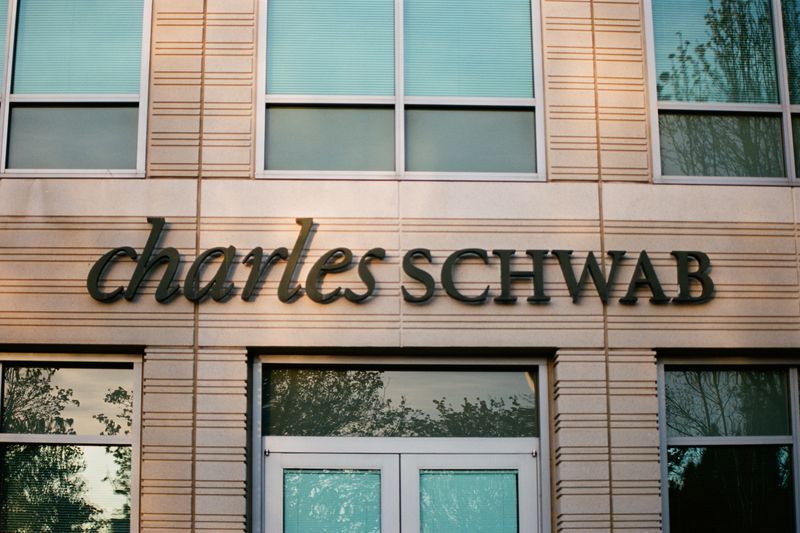Image shows the front of a Charles Schwab building with the words on the building reading "Charles Schwab."