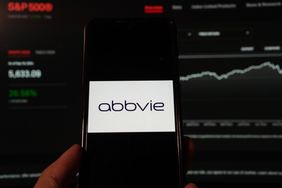 AbbVie Inc. logo is displayed on a smartphone with a S&P index website background