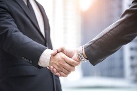 Two people shake hands.