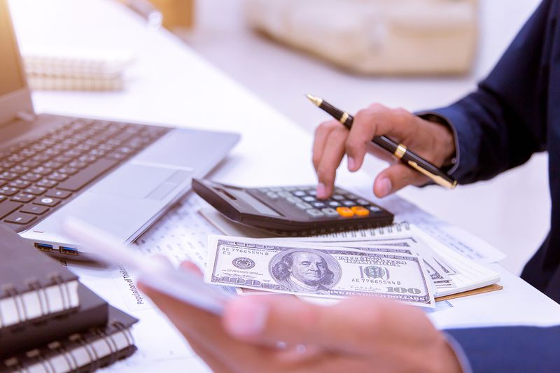 The Midsection of Businessman Using Mobile Phone on Table