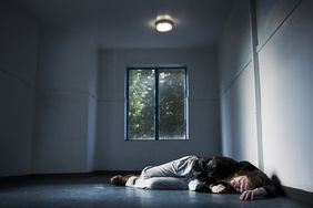 Man laying on floor in empty room.