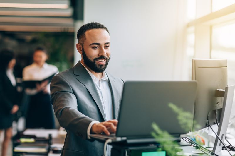 Man smiling in front of a computer