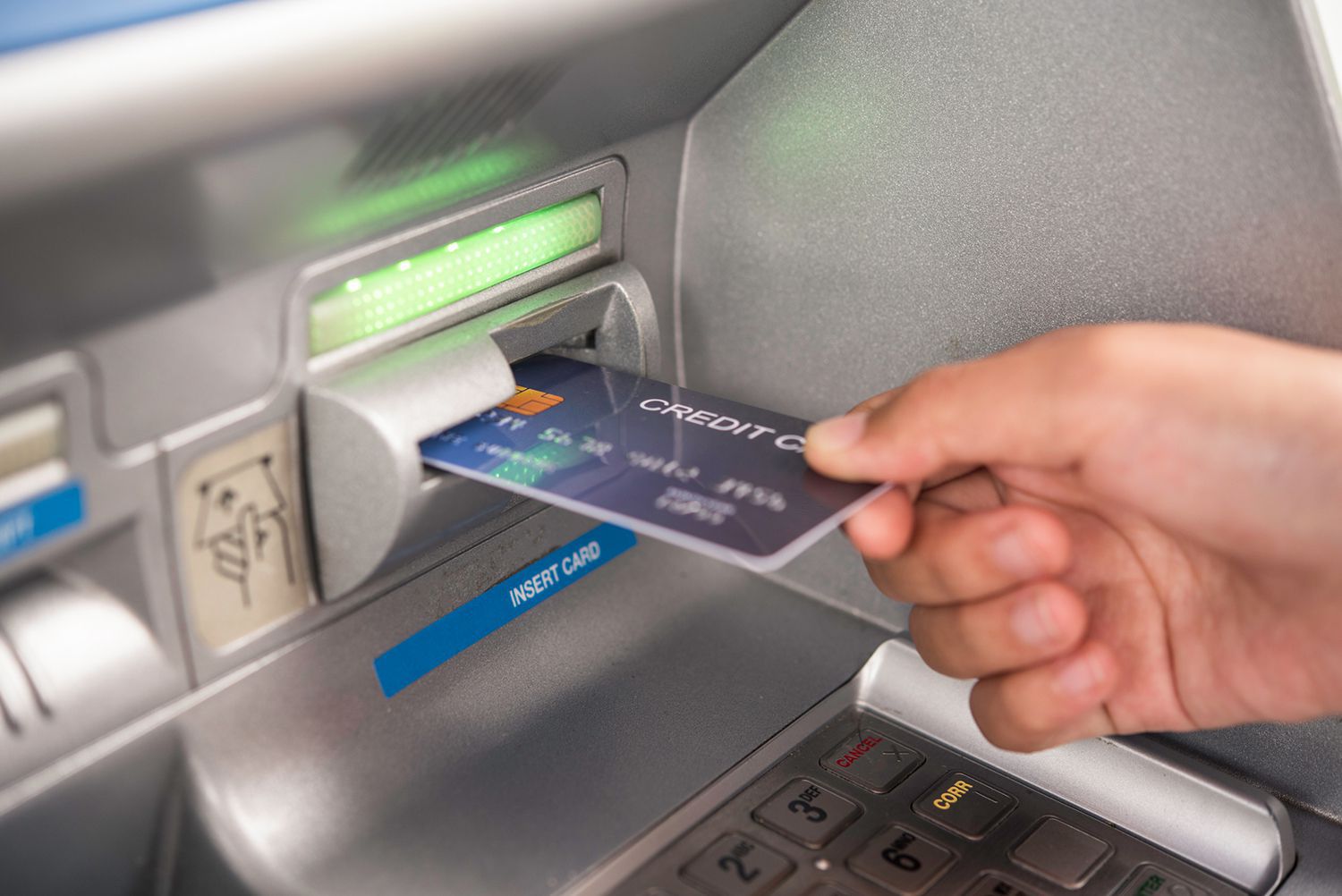 Someone inserting a credit card in an ATM