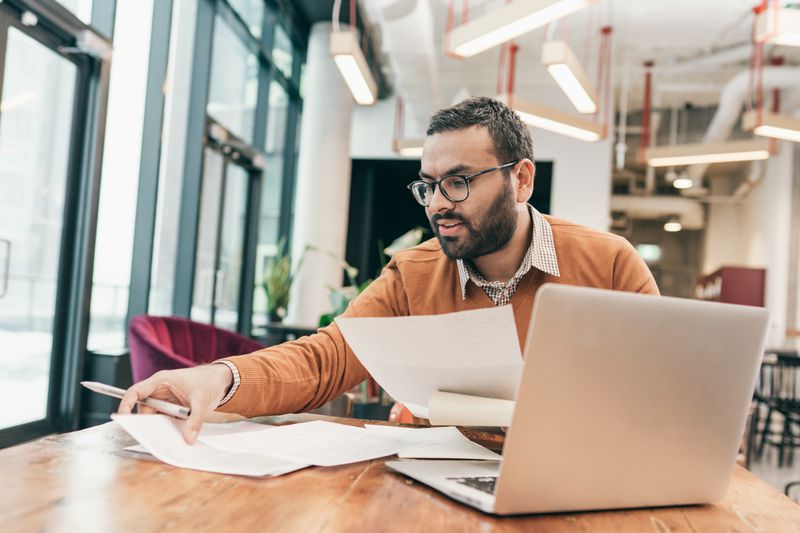 Person sitting at a desk in an office collecting paperwork