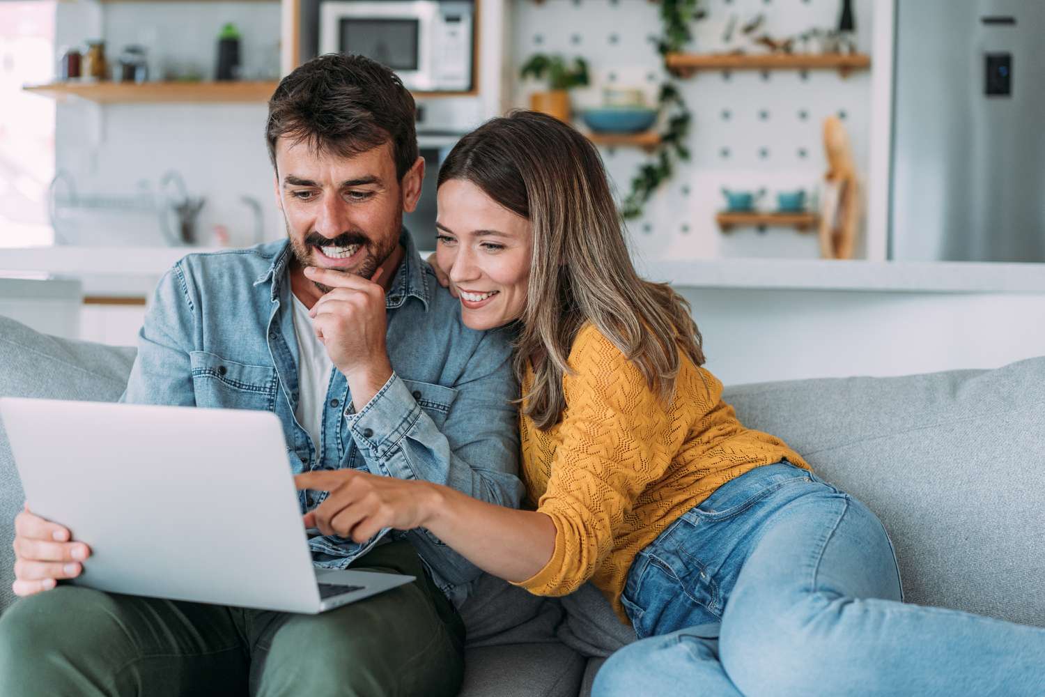 Shot of an adorable smiling young couple using laptop together at home.