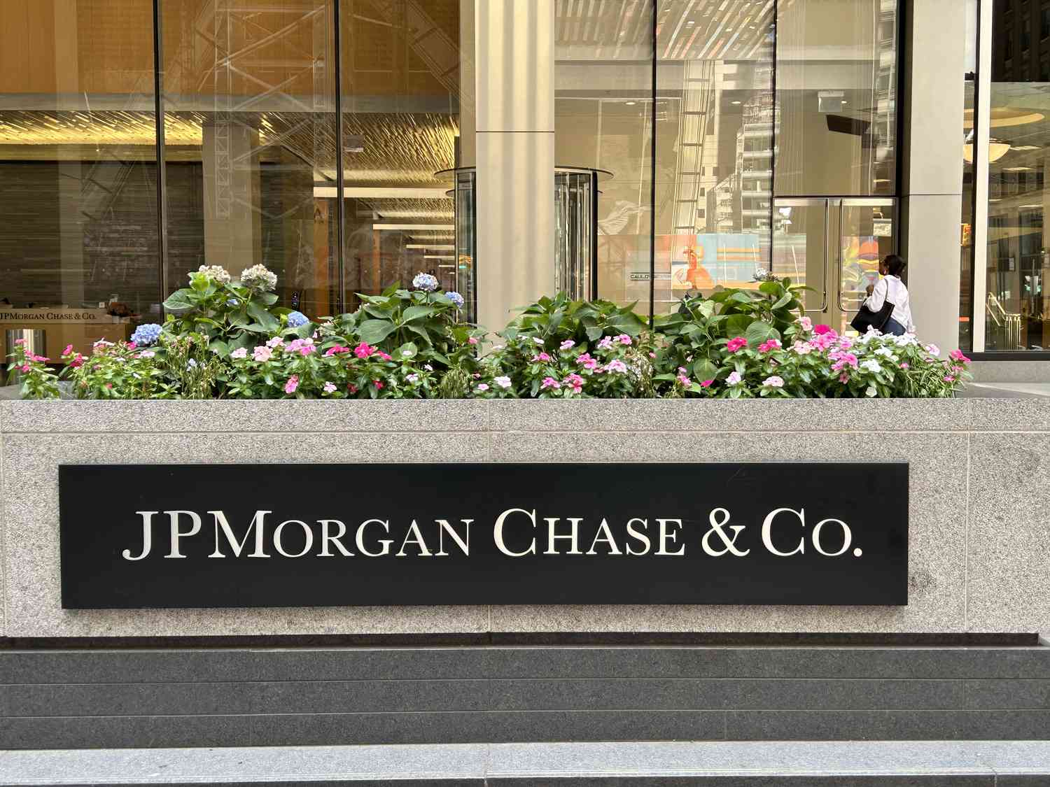 The JPMorgan Chase sign is seen outside a building with flowers growing above it.