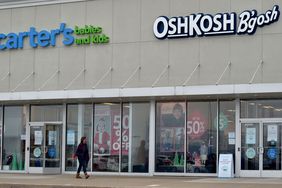 A person walks in front of a pair of Carter's Babies and Kids and OshKosh B'Gosh stores.