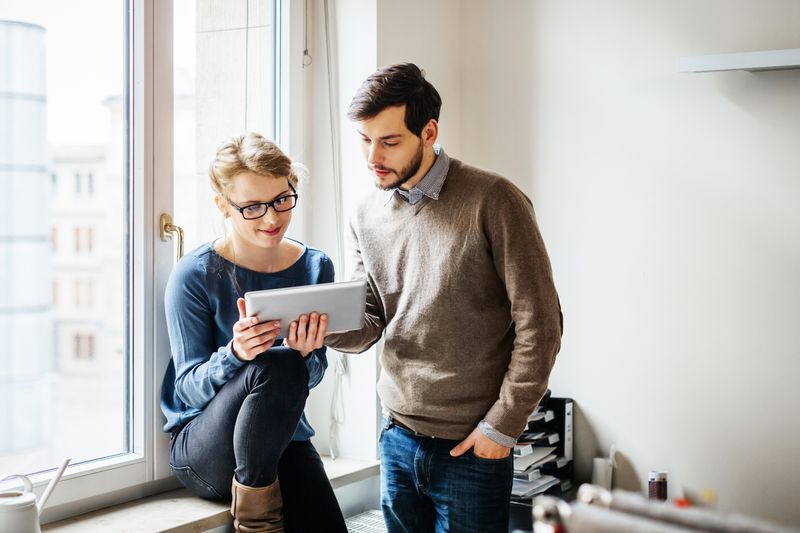 Two people review a device.