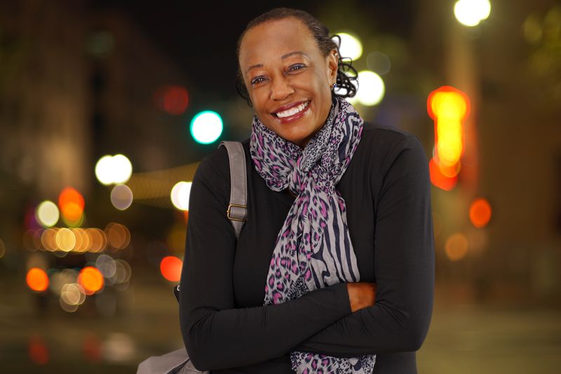 Stylish older woman against backdrop of evening city lights