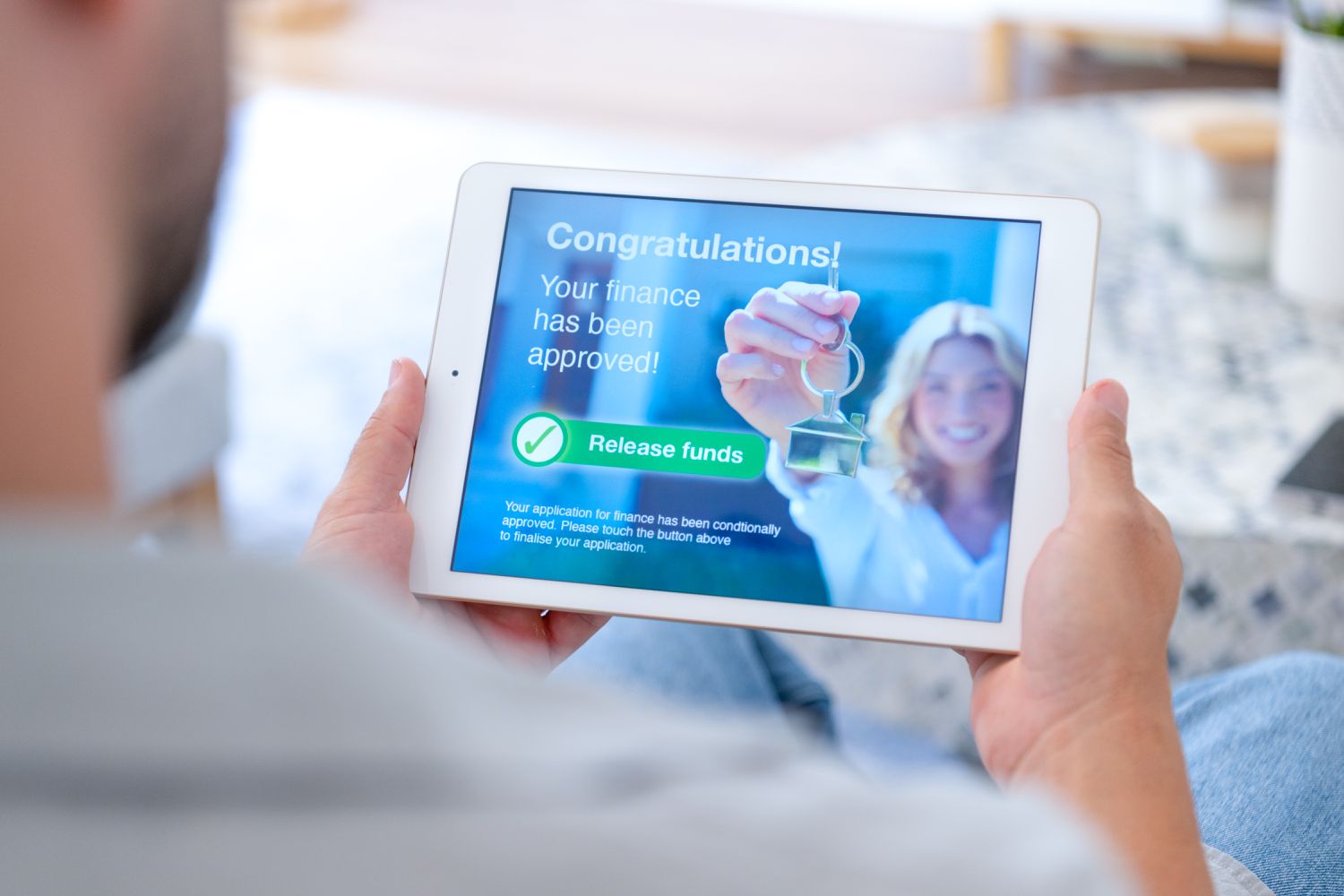 Person holding a digital device with a mortgage application approval. 