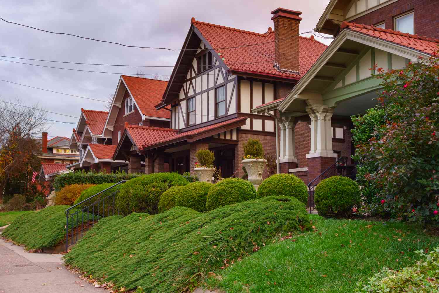 Row houses with red brick, beige siding and brown details with green lush lawns in Charleston, West Virginia.