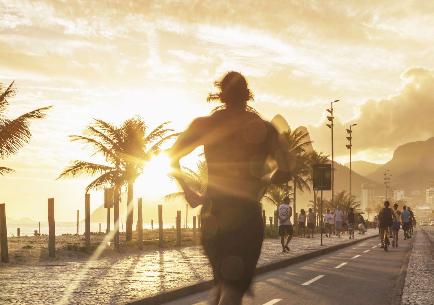 Man jogging on a sidewalk next to Ipanema beach in Brazil