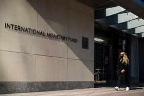 A woman walking past an International Monetary Fund building.