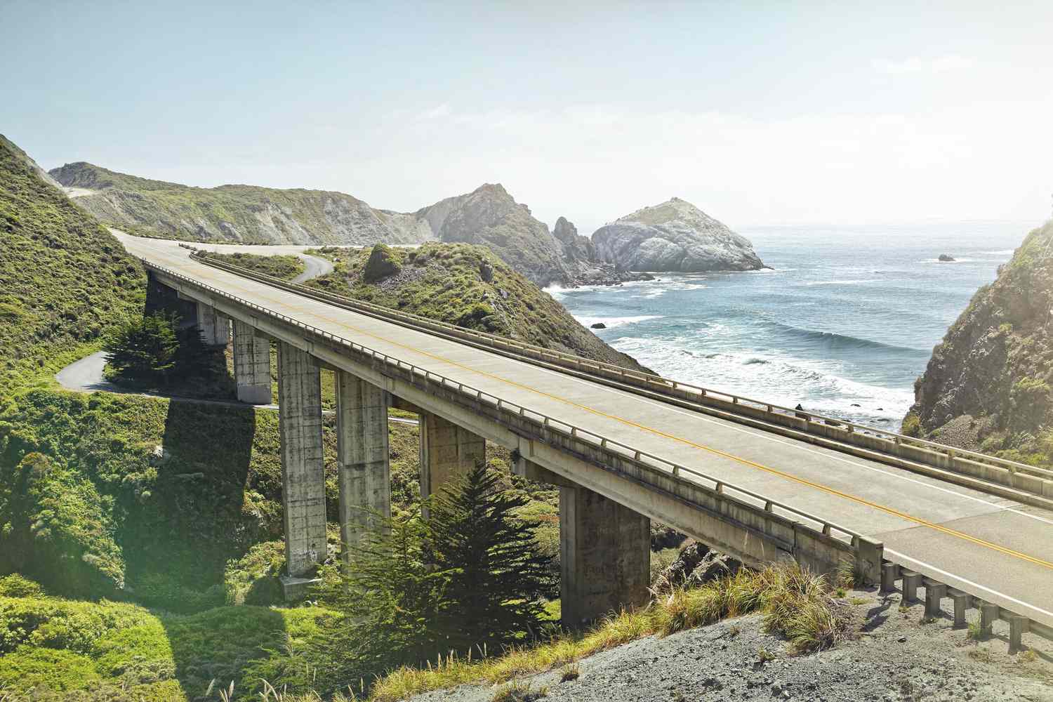 A panoramic view of Big Sur highway in California, showcasing mountains and the ocean.